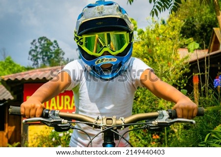 kid riding bike with helmet an googles for protection 