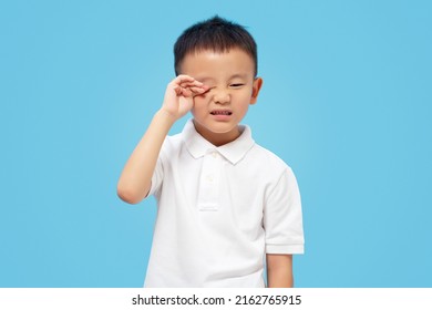 Kid Rubbing Eye, Allergy And Itching, Sore Eyes, Wearing White Shirt On Blue Background