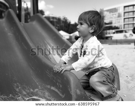 
The kid runs around on the playground and rolls on the hill