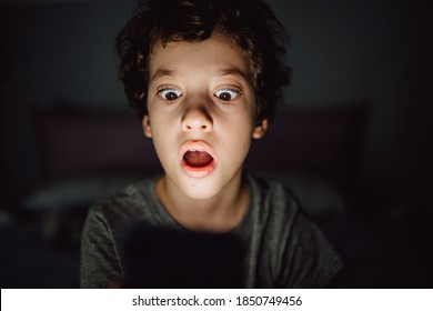 Kid scared watching online adult content video on the smartphone. Concept of children addiction of new technologies and the dangers of the internet. - Shutterstock ID 1850749456