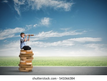 Kid Of School Age Sitting On Pile Of Books And Looking In Spyglass