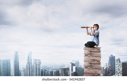 Kid Of School Age Sitting On Pile Of Books And Looking In Spyglass