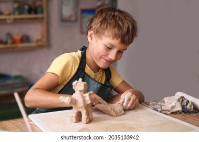 Kid sculpts clay crafts pottery school.