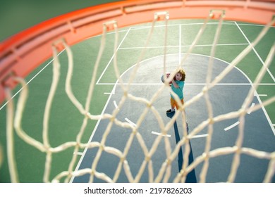 Kid Shooting Basketball Ball And Playing Basketball. Healthy Children Lifestyle, Outdoor On Playground.