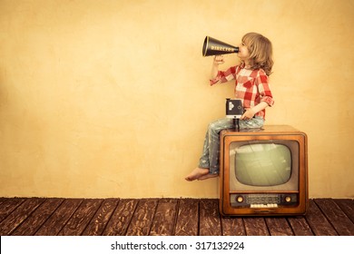 Kid shouting through vintage megaphone. Communication concept. Retro TV