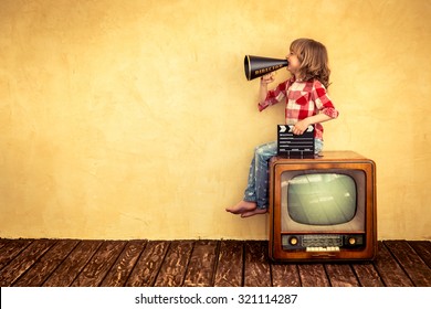Kid shouting through vintage megaphone. Communication concept. Retro TV - Shutterstock ID 321114287
