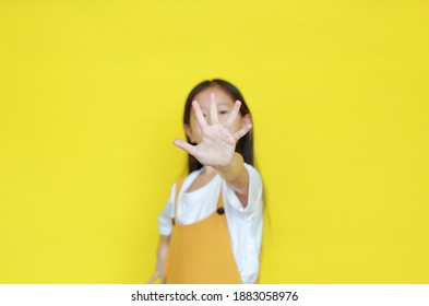 Kid Showing Stop Sign Gesture Isolated On Yellow Background. Child Show Palm Of Hand, Selective Focus At His Five Fingers.