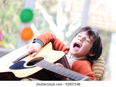 Kid Singing And Playing Guitar At Home