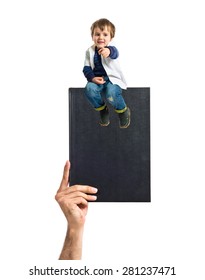 kid sitting on book
