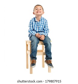 Kid Sitting On A Wooden Chair Over White Background