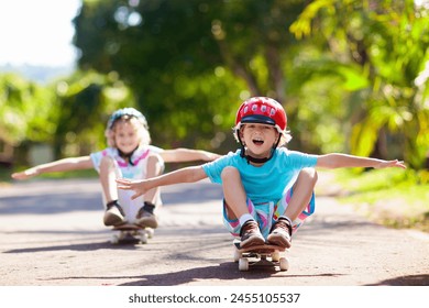 Kid with skateboard. Child riding skate board. Healthy sport and outdoor activity for school kids in summer. Sports fun. Helmet for safe exercise. Boy skater in sunny park. Children training. - Powered by Shutterstock