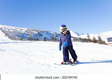 Kid In Ski Mask Skiing On Snow Downhill