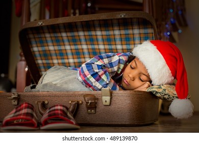 Kid Sleeping Inside Cozy Suitcase. Boy's Christmas Nap Inside Suitcase. Little Santa Needs Some Rest. Cozy Place To Sleep In.