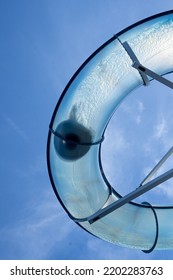 Kid Sliding Down A Transparent Water Slide Seen From Below.	