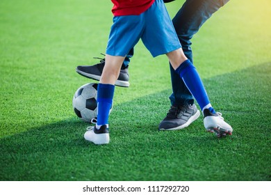 Kid Soccer And Dad Are Playing Ball On At Artificial Turf.