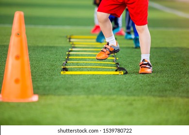 Kid soccer player Jogging and jump between marker for football training. Ladder drills exercises for football soccer team. Kid player exercises on ladder drills.