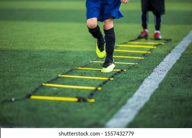 Kid soccer player Jogging and jump between ladder drills for football training. Ladder drills exercises for football or soccer team. Kid soccer player exercises on ladder drills. - Powered by Shutterstock