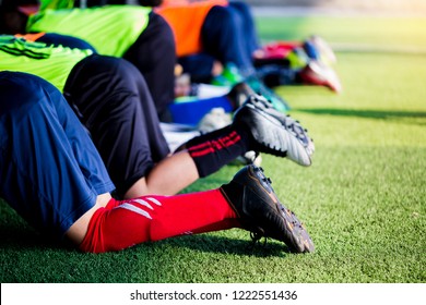 Kid soccer players are push up exercise with warming on green artificial turf for stretch muscles before and after play soccer game. Football or Soccer Academy. - Powered by Shutterstock