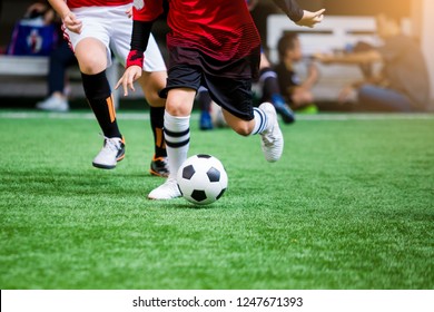 Kid soccer players standing for start kick off the game at center circle on green artificial turf. Kid soccer players fighting each other by kicking the ball. - Powered by Shutterstock