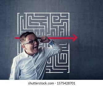 Kid Solving A Maze Using A Shortcut. Maze Drawn On Blackboard .