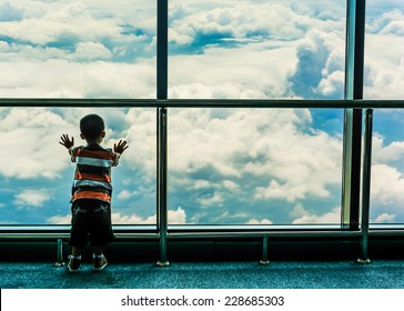 Kid Standing And Looking Through The Window