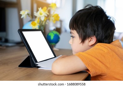 Kid stay at home watching cartoon on tablet, Child using digital tablet searching information on internet for his homework during covid-19 lock down,Social Distancing, learning online education
