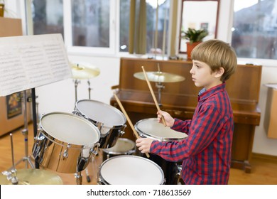 Kid studying drums at school