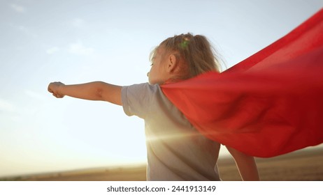 kid superhero. girl daughter happy family dream concept. baby girl superhero close-up in red cape at sunset. portrait child superhero close-up from the back. strength fantasy lifestyle concept - Powered by Shutterstock