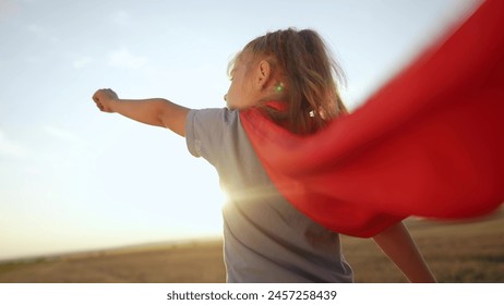 kid superhero. girl daughter happy family dream concept. baby girl superhero close-up in red cape at sunset. portrait child superhero close-up from the back. strength lifestyle fantasy concept - Powered by Shutterstock