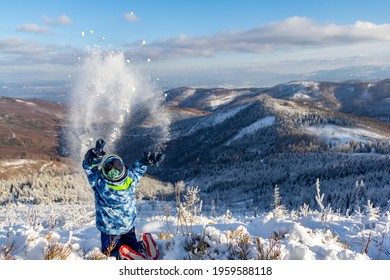 Kid Throwing Snow Up In The Air In Polish Mountains During Sunny Winter Day In Malinowska Skala, Szczyrk