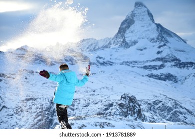 Kid Throwing Snow Up In The Air In Zermatt Matterhorn Switzerland 