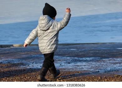 Kid Throwing Stone In Water. Child In Action Of Throwing Stone Or Rock In Water