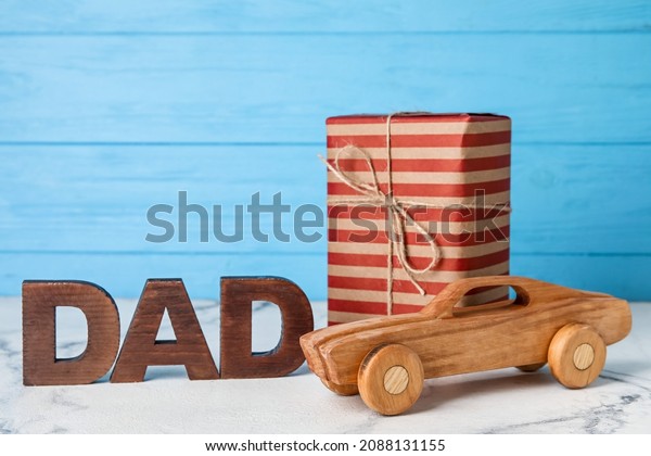 Kid toy with gift for\
father on table