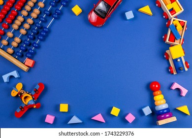 Kid Toys Background. Wooden Educational Geometric Stacking Blocks Toy, Wooden Train, Airplane And Colorful Blocks On Navy Blue Background. Top View, Flat Lay