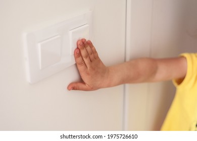 Kid Is Turning On Or Turning Off The Light-switch With White Wall.