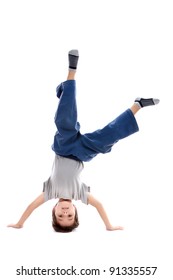 A kid upside down smiling to the camera, looking like a circus artist or maybe a capoeira fighter which is a native Brazilian fight style. Isolated on white.