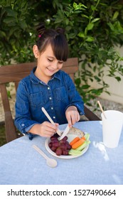 Kid Using Disposable Wooden Cutlery To Eat Her Healthy Snacks After School.