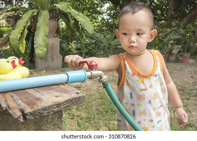 Kid  Using Hand Close Faucet To Turn Off Water  