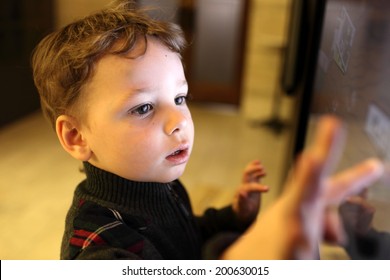 Kid Using Interactive Touch Screen In A Museum