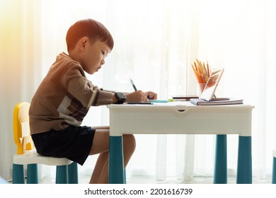 Kid using tablet and smartphone learning online at home,child practice drawing from a smartphone