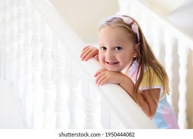 Kid Walking Stairs In White House. Little Girl Playing In Sunny Staircase. Family Moving Into New Home. Child Climbing Steps Of Modern Stairway. Foyer Or Living Room Interior. Home Safety For Toddler.