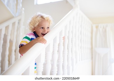 Kid Walking Stairs In White House. Little Boy Playing In Sunny Staircase. Family Moving Into New Home. Child Climbing Steps Of Modern Stairway. Foyer And Living Room Interior. Home Safety For Toddler.