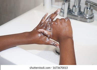 Kid Washing hands in bathroom sink