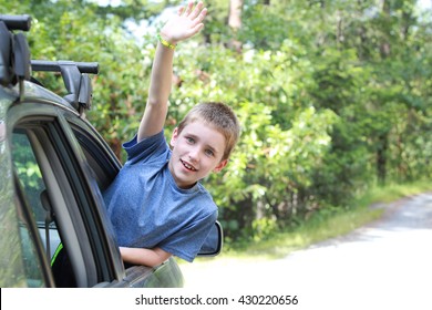 A Kid Waving Goodbye Out A Car Window