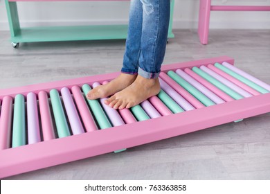 Kid Wearing Jeans Standing On The Pink And Mint Massage Mat Barefoot