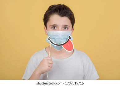 Kid Wearing Medical Mask And Smile False On Stick Over Yellow Background