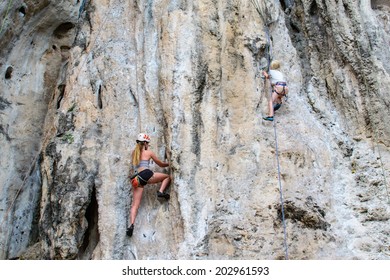 Kid And Woman Climbing On The Rock