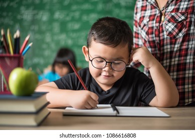 kid  write a book in the classroom.