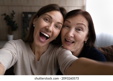 Kidding With Mommy. Joyful Grown Daughter Joking Laughing Taking Funny Selfie Together With Retired Mother. Young And Elderly Women Two Sisters Mom And Adult Child Have Fun At Home Shoot Self Portrait