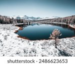 Kidelu lake in Altai mountains, Siberia, Russia. Snow-covered trees and mountains. Aerial drone view. Winter landscape.